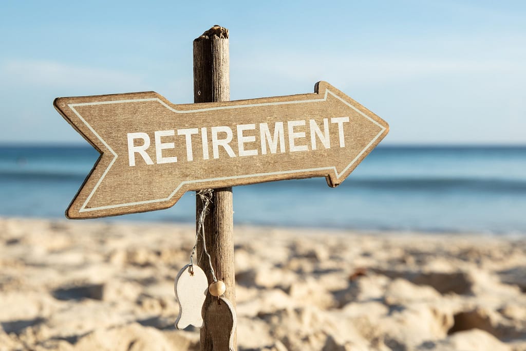 Retirement sign on the beach symbolizing future planning and 2025 IRA contribution limits for savings and financial security.
