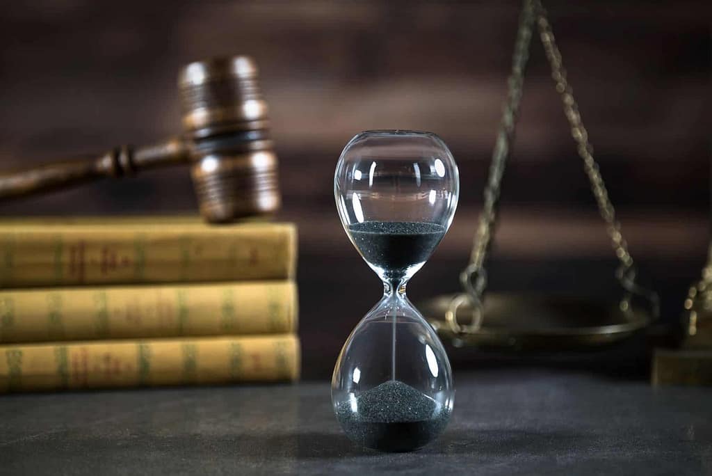 a hourglass with black sand in front of a gavel